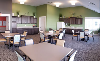 this is a photo of a cafeteria with several tables and chairs around it . and there is a large cupboard on the wall