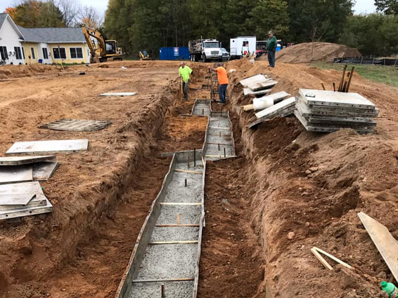 construction workers laying foundation for new building expansion